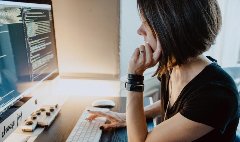 A woman with short brown hair looking at a computer screen