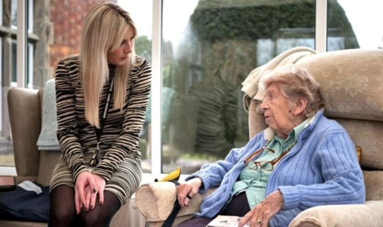 Image of an older woman sat on a chair with you a younger woman