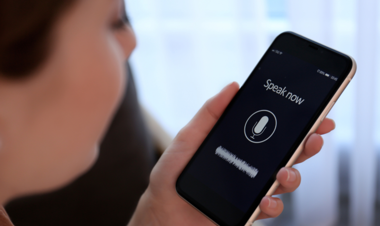 A woman speaking into a phone to dictate her voice message