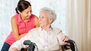 Middle aged woman and older woman sat closely together smiling