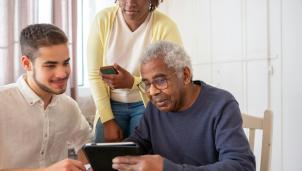 three people using digital devices in care