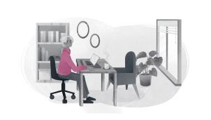 Care worker sat at a desk with a laptop