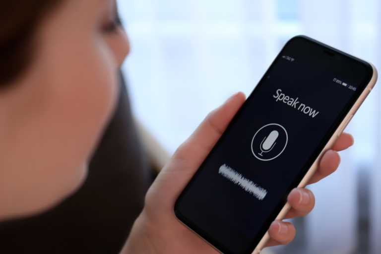 A woman speaking into a phone to dictate her voice message