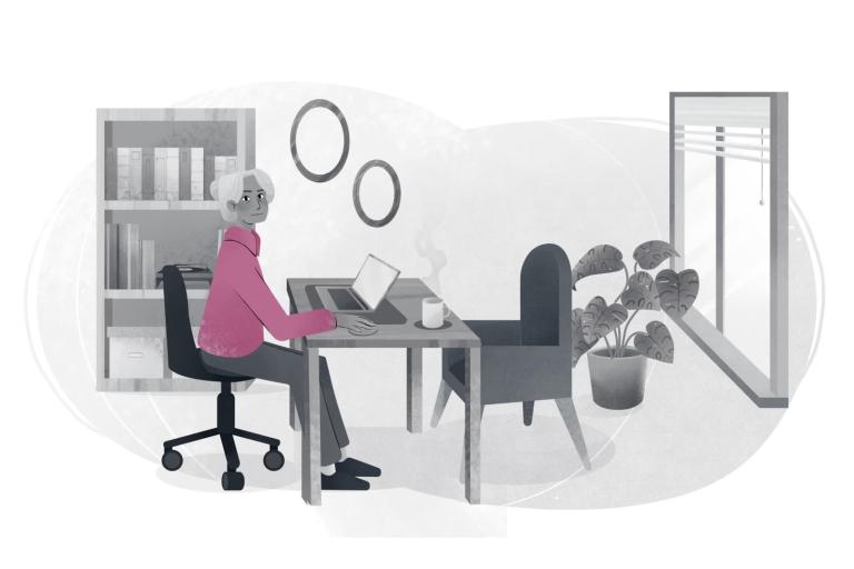 Care worker sat at a desk with a laptop